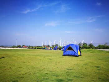 Tent in field against blue sky