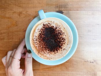 Person holding coffee cup on table