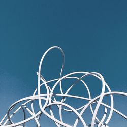 Low angle view of ferris wheel against blue sky