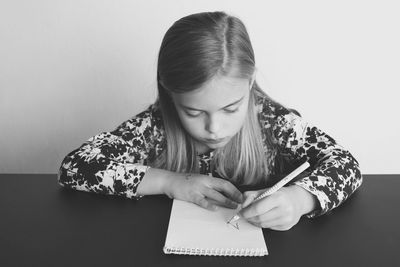 Close-up of girl looking down against white background