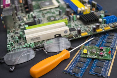 High angle view of circuit board with eyeglasses and pen on table