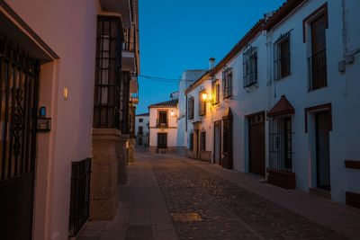 Narrow street amidst buildings at night