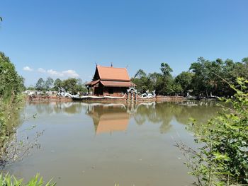 Reflection of building in lake against clear sky