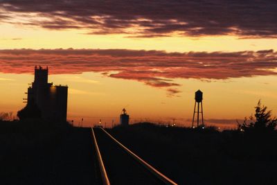 Silhouette of city against sky during sunset