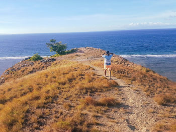 Rear view of man on beach against sky