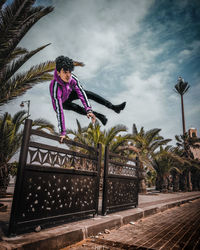 Full length of woman with palm trees against sky