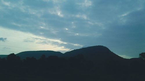 Low angle view of silhouette mountain against sky at night