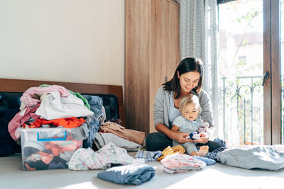 Mother and daughter sitting on bed