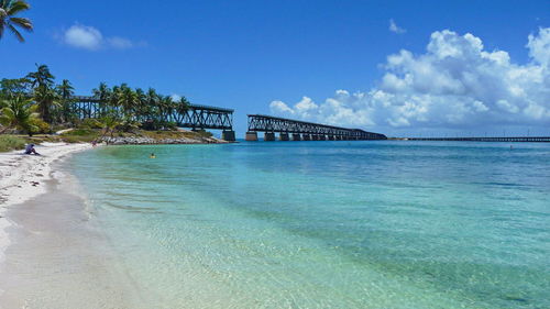 View of bridge over sea against cloudy sky