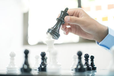 Cropped hand of man holding chess