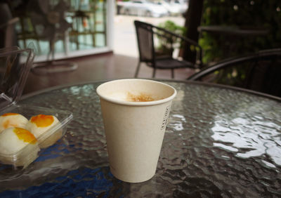 Close-up of paper coffee cup on table