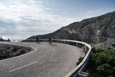 Scenic view of road by mountain against sky