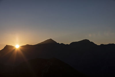 Scenic view of silhouette mountains against sky during sunset