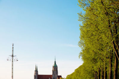 Low angle view of trees and buildings against sky