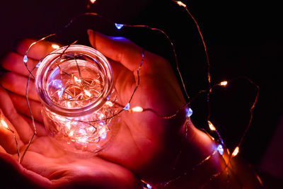 Close-up of hand holding illuminated string light