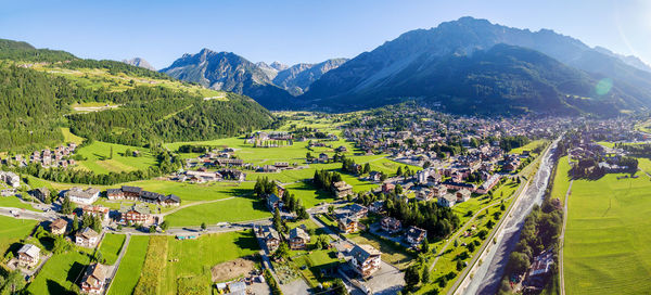 High angle view of townscape on field by mountain against sky