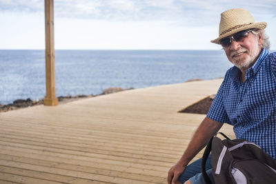 Man wearing hat by sea