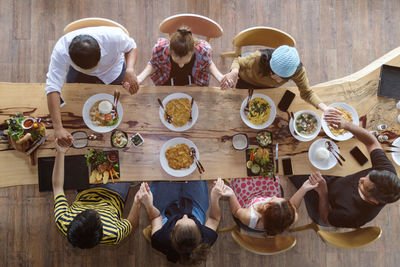 High angle view of family praying at dining table