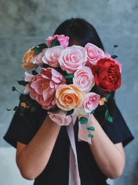 Midsection of woman holding rose bouquet