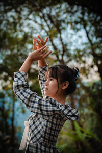 Side view of young woman using mobile phone