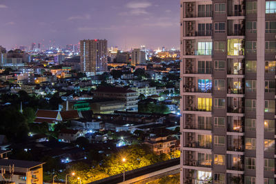 Illuminated buildings in city against sky at night