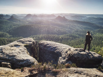 Adult cow woman standing on a rock with head held. beautiful sunrise view and sea of mist in morning