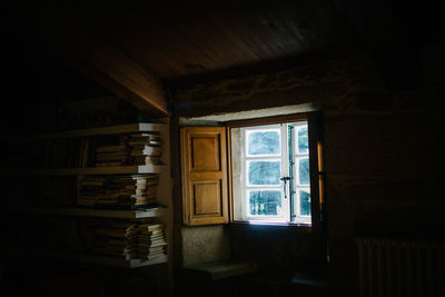 Books on shelves by window at home