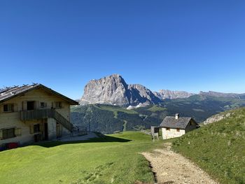 Scenic view of houses and mountains against clear blue sky