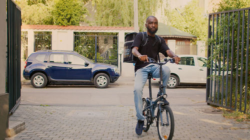 Side view of man riding bicycle on street