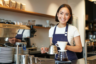 Portrait of young woman standing in cafe