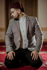 Young man looking away while sitting outdoors