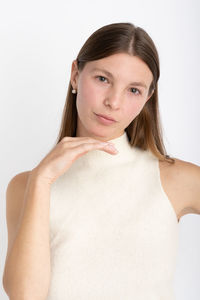 Portrait of young woman against white background