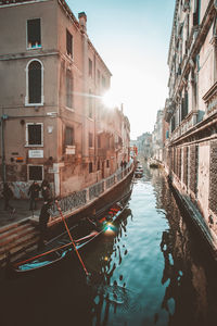 Gondolier rowing on gondola - traditional boat in canal against sky