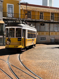 Train on railroad tracks by buildings in city