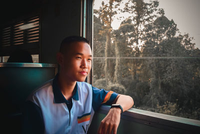 Portrait of mid adult man sitting in window