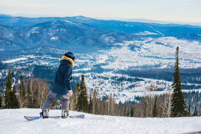 Full length of man snowboarding on snowcapped mountains