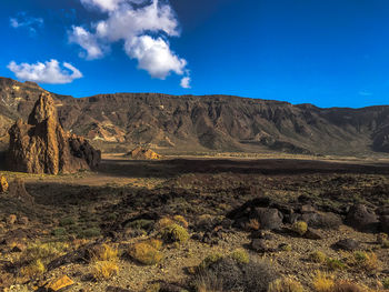 Scenic view of landscape and mountains against blue sky