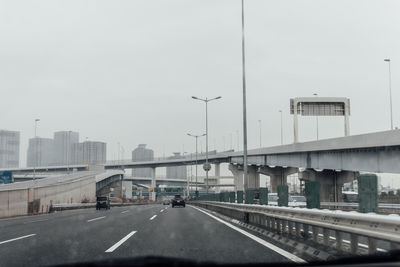 Cars on road in city against clear sky