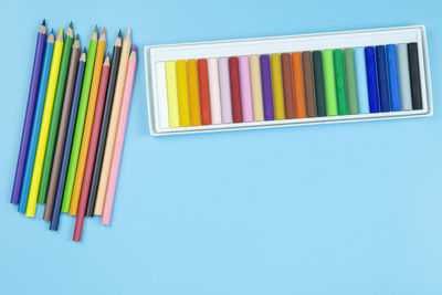 Close-up of multi colored pencils against blue background