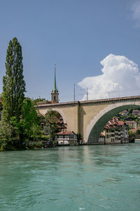 Arch bridge over river against sky