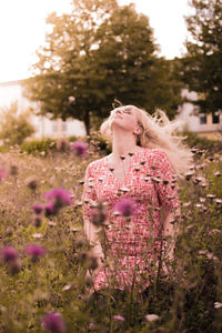 Young woman amidst flowers in field