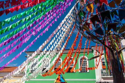 Low angle view of multi colored flags against sky