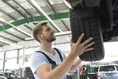 Car mechanic in a workshop changing car tyre