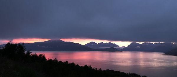 Scenic view of lake and mountains against sky at sunset