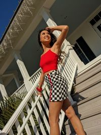 Low angle view of woman standing against railing