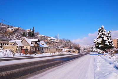 Road against clear blue sky during winter