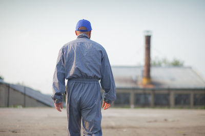 Rear view of man standing at construction site