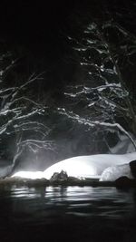 Frozen lake against sky at night