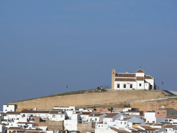 Buildings in town against clear blue sky