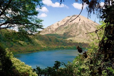 Scenic view of lake by mountains against sky